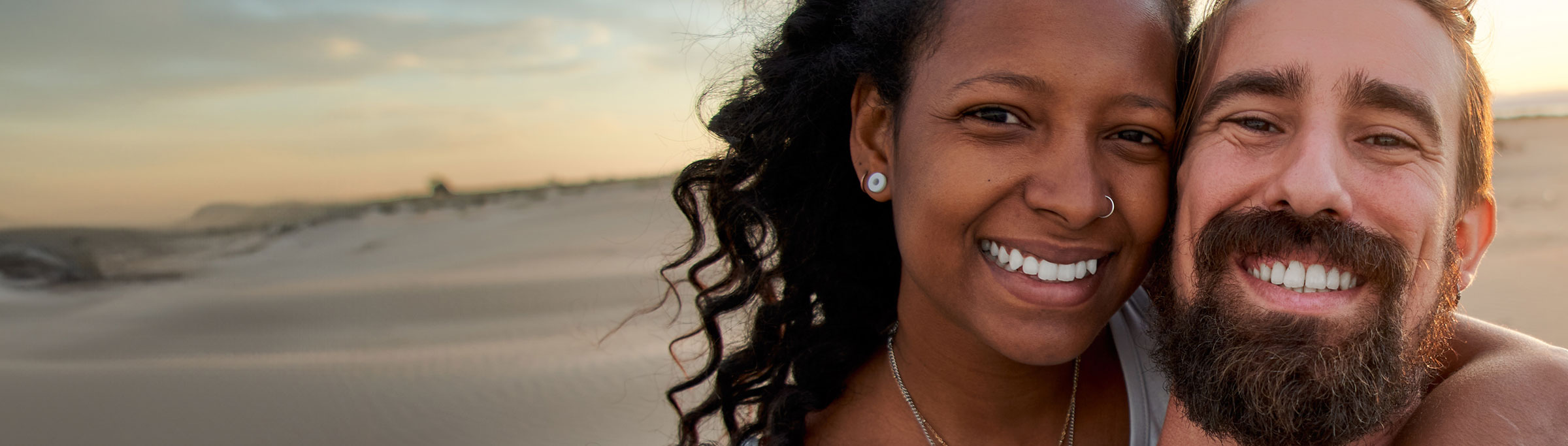 Close up face picture of happy couple  smiling while at the beach